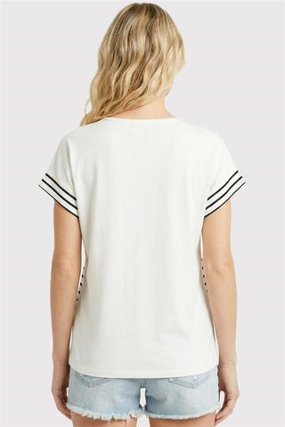 Back view of woman wearing ivory and black striped short sleeve split neck jersey knit top with denim shorts