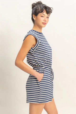 woman wearing navy striped sleeveless romper with drawstring waist and pockets side view