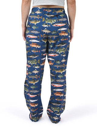 Person wearing blue pants with fish pattern on a white background