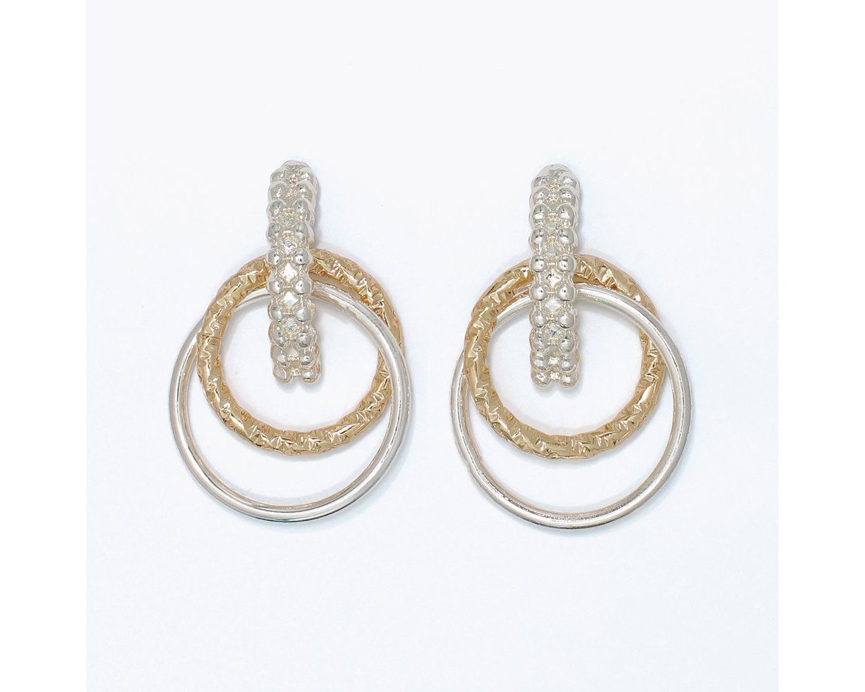 Two-tone textured drop earrings featuring layered gold-tone and silver-tone circular rings in a modern mixed-metal design.
