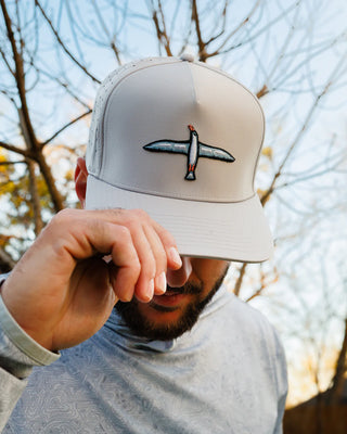 Person wearing Waggle Albatross snapback golf hat with embroidered bird logo