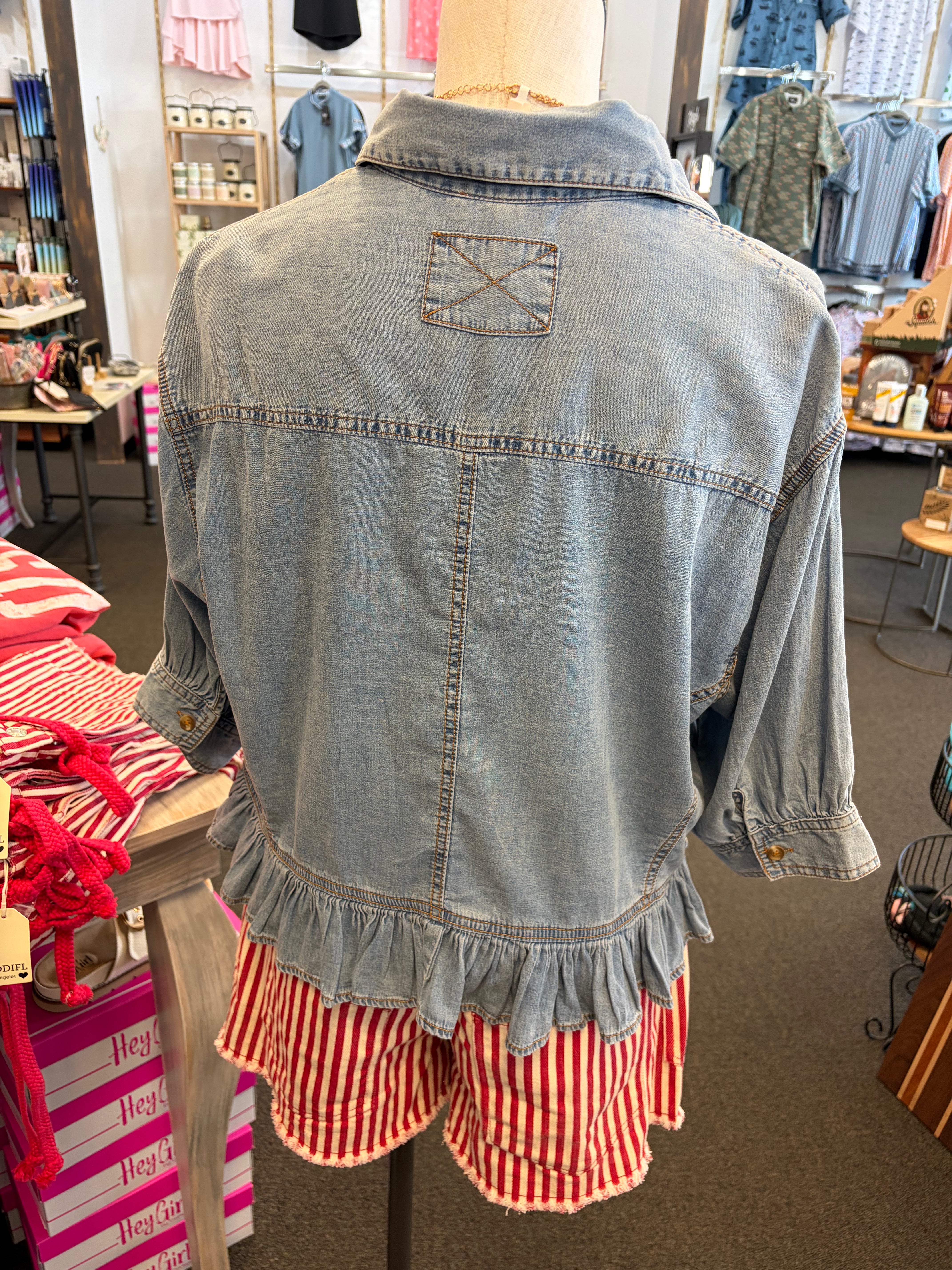 Back of Women’s lightweight denim button down top with ruffle hem and relaxed fit