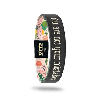 Wristband with floral design and motivational text on a white background